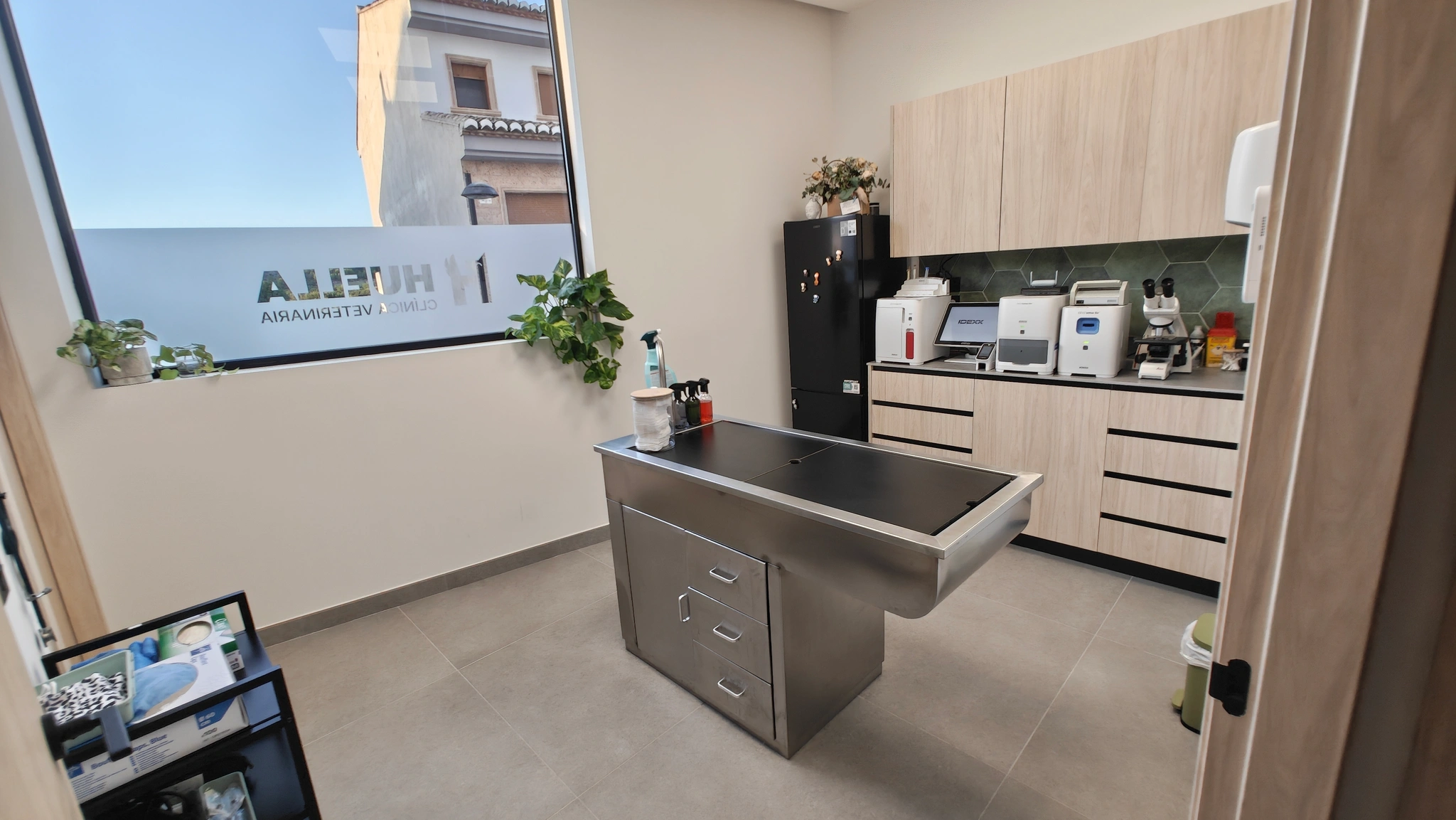 Sala de preoperatorio, con mesa de acero y el laboratorio propio al fondo